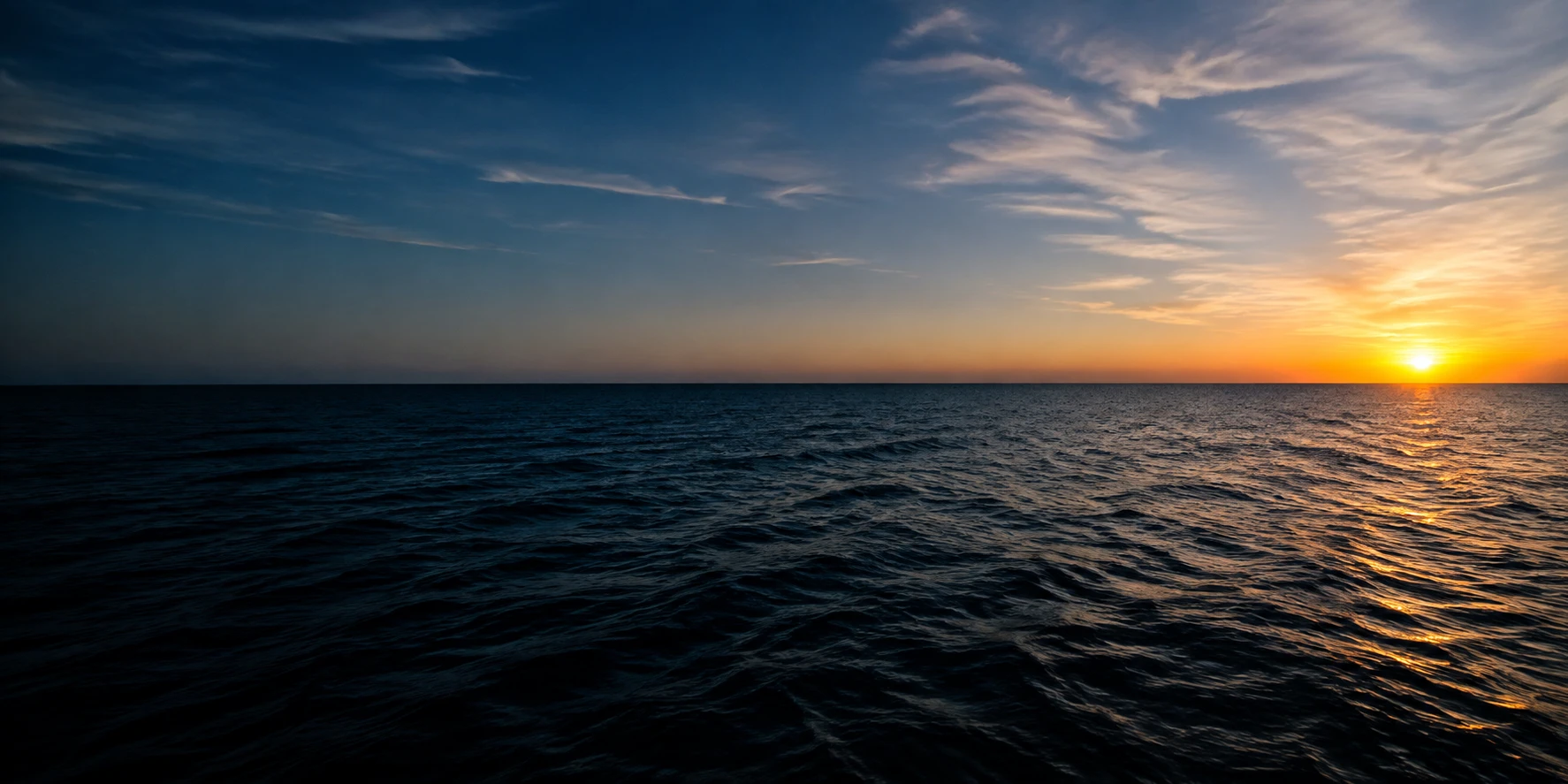 Golden light over deep blue ocean water